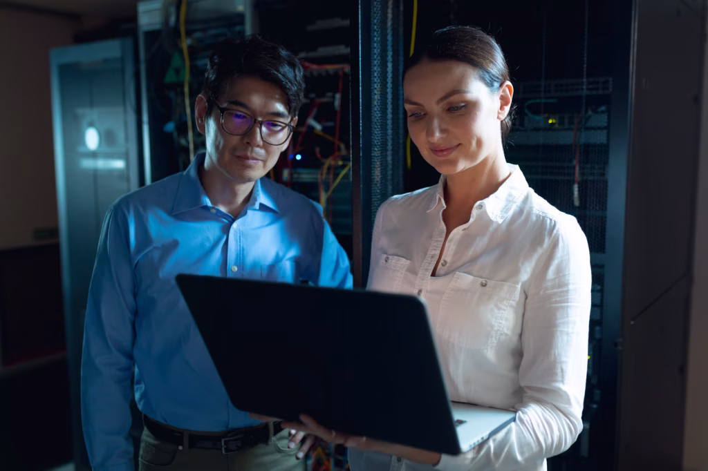 System Engineers Reviewing Laptop in Data Center