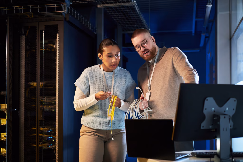 Technicians Inspecting Network Cables Inside Data Center